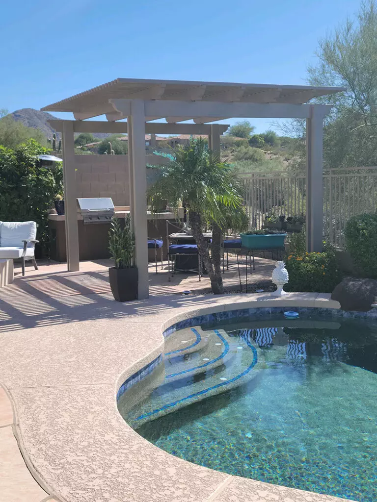 white pergola installed next to pool