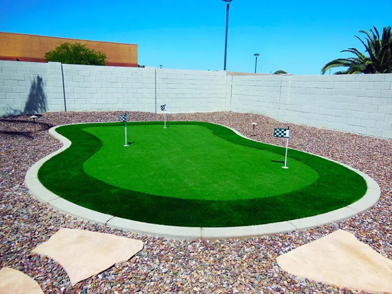 putting green in backyard next to gravel and flagstone pavers